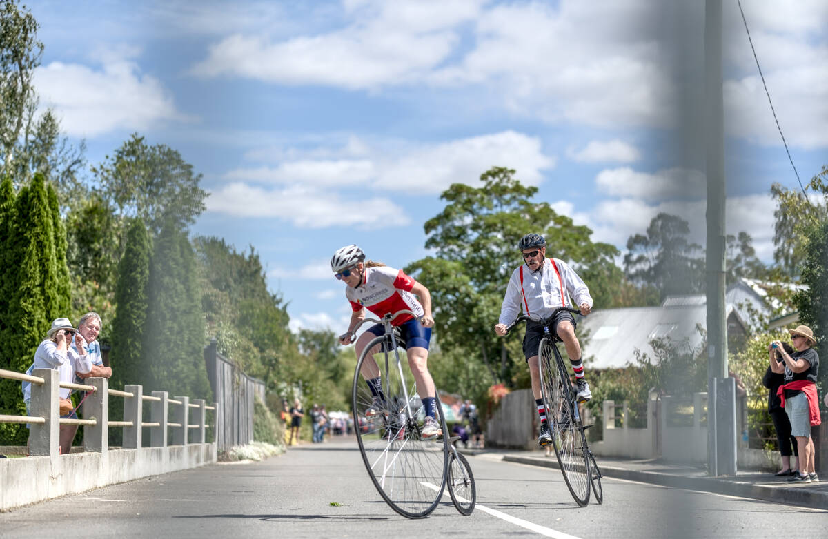 two penny farthing riders in a close race