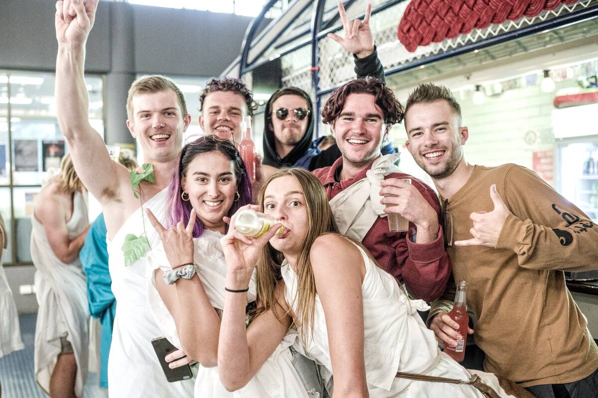 group of young people in togas smiling at the camera
