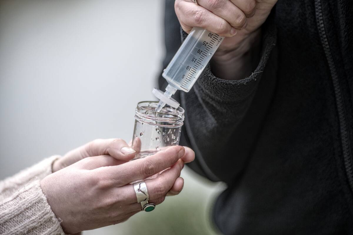 closeup of hands sampling water with scientific equipment